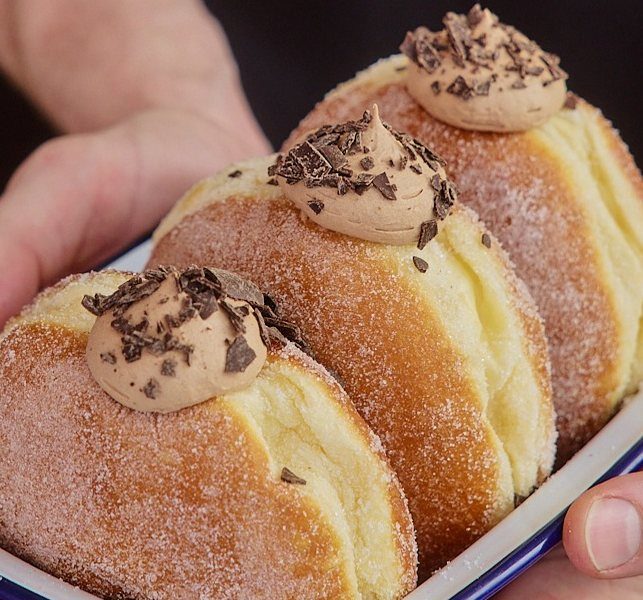 Three Triple Chocolate Mousse doughnuts held in an enamel dish
