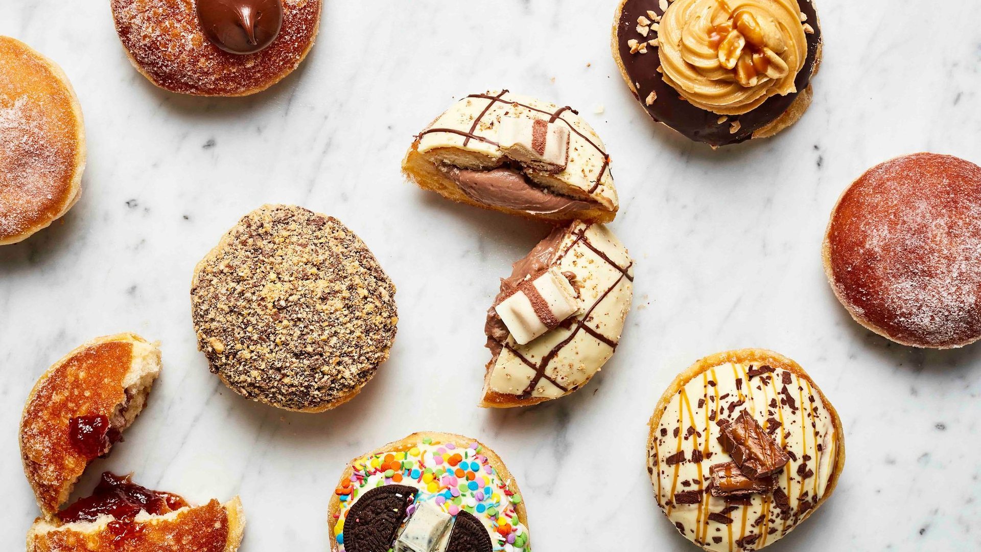 Bistro Morgan brioche doughnuts with different fillings and toppings on a marble bench
